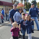 Fireman Matt Moreno, spouse Kirby, and daughter Mayce join Kiani Shiyomura and Charlee Areies in raising the tree.